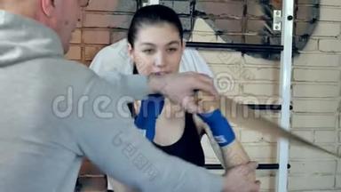 在健身室用橡皮筋进行漂亮的跆拳道女子训练拳打脚踢，强壮有力，适合身体的跆拳道